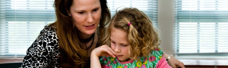 Clinician reading with young girl Clinician reading with young girl