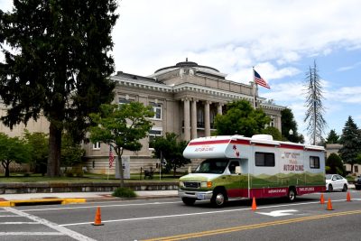The Mobile Autism Clinic drives through downtown Marion, Virginia. Behind the RV is Marion's picturesque historic courthouse, with an America flag atop it.