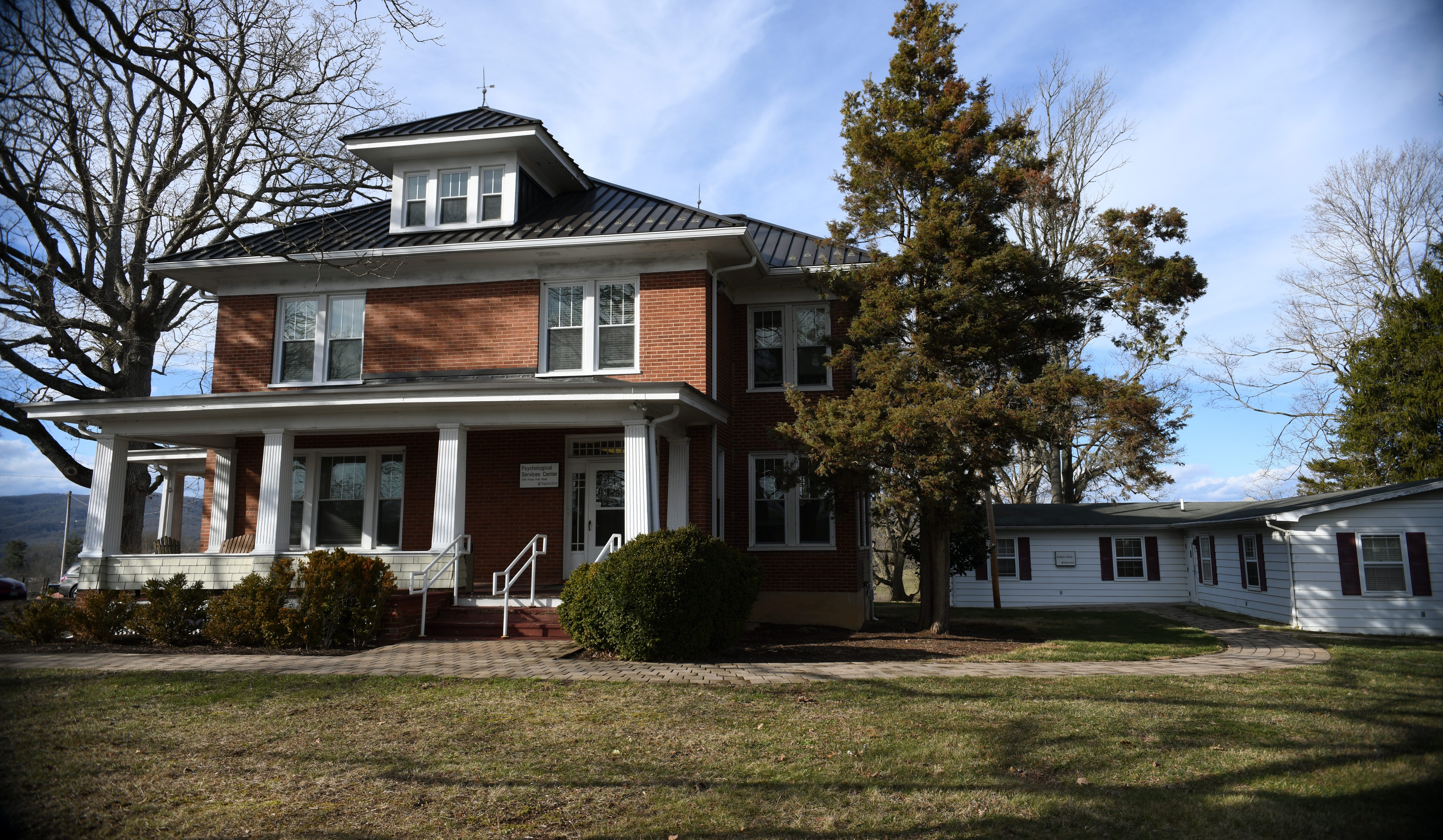 VT Psychological Services Center, a two story brick building, on left and the VT Autism Clinic, a one story white building on right