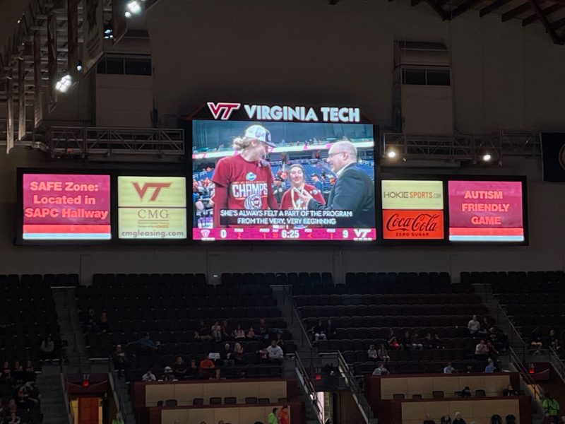 Screen of jumbotron at the game, with player Liz and her sister Raven Kitley being interviewed.