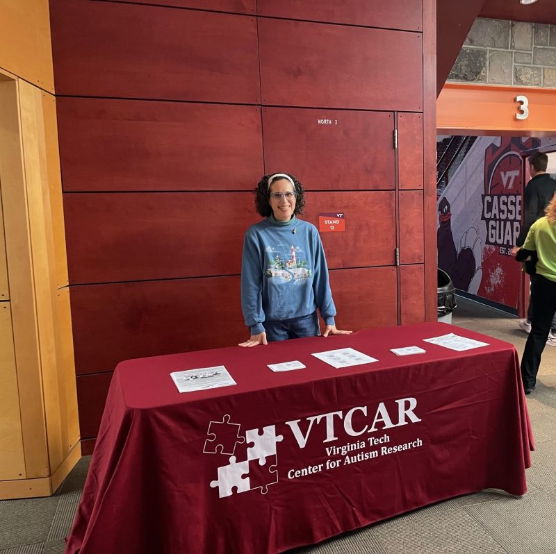 VTAC/CAR director Angela Scarpa standing at the information table during the game.